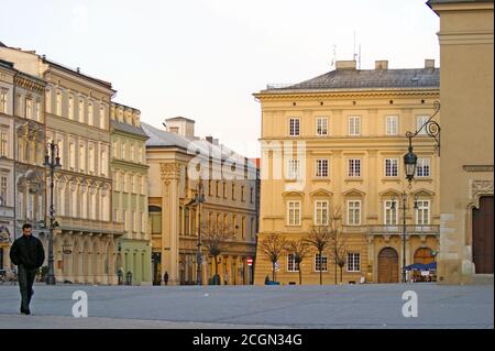 Ein einsamer Mann geht am frühen Morgen am 6. Januar 2010 in Krakau, Polen, durch den Marktplatz der Altstadt von Krakau. Stockfoto