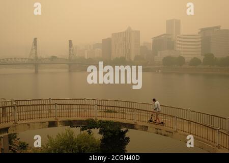 Portland, USA. September 2020. Eine Person fährt ihren Roller auf die Morrison Bridge von der Eastbank Esplanade als Wildfire Rauch verschlingt Portland, Oregon, am 11. September 2020. Mehr als eine Million Hektar haben im ganzen Staat verbrannt, als es mit historischen Waldbränden, die über 500,000 Menschen vertrieben haben, zu Graben geht. (Foto: Alex Milan Tracy/Sipa USA) Quelle: SIPA USA/Alamy Live News Stockfoto