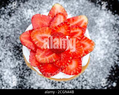 Köstliche Pavlova mit Erdbeere in Black Plate und Zucker Stockfoto