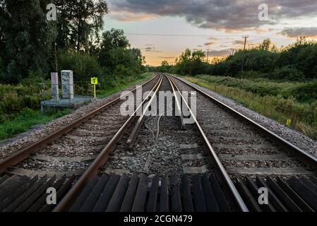 Eisenbahnstrecke in der Landschaft unter einem Sonnenuntergang Himmel Stockfoto