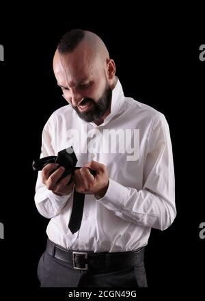 Junger hispanischer Mann wütend auf seine Krawatte Stockfoto