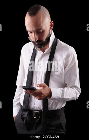 Schöner hispanischer Mann, der sein Telefon beim Anziehen überprüft Stockfoto