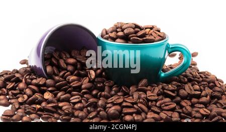 Tassen Kaffee mit Bohnen in und verschüttet um isoliert Auf Weiß Stockfoto