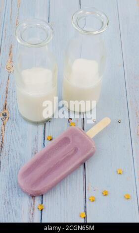 Traube Popsicle Whit Milch auf blauem Hintergrund rustikal Stockfoto
