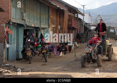 Alte Häuser, Laden und Traktor, Husa, Präfektur Dehong, Südwest Yunnan, China 6. März 2008 Stockfoto
