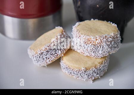 Argentinische Tradition: Nahaufnahme von köstlichen Maisstärke-Alfajores auf dem Tisch vor dem heißen Aufguss von Yerba Mate Stockfoto