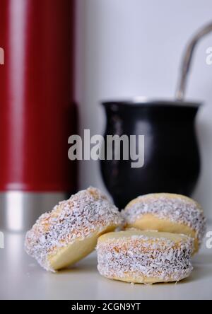 Argentinische Tradition: Nahaufnahme von köstlichen Maisstärke-Alfajores auf dem Tisch vor dem heißen Aufguss von Yerba Mate Stockfoto