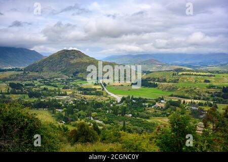 Arrow Junction Lookout Point, ein Bergblick mit Blick auf Berge und Dörfer. Im Sommer gibt es wilde Blumen und grüne Felder bei Crown Stockfoto