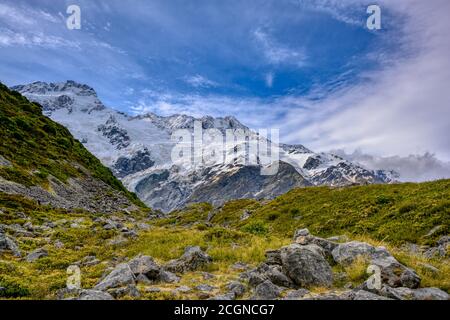 Kea Point Track im Mount Cook National Park, hohe felsige Berge und grünes Gras im Sommer in Neuseeland Stockfoto