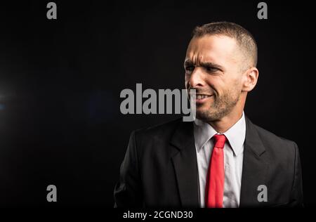 Überraschte Mann im Anzug. Schwarzer Hintergrund, Nahaufnahme. Stockfoto
