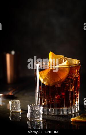 Frisch zubereitetes Cuba Libre Cocktail mit braunem Rum, Cola und Zitrone auf Holzhintergrund Stockfoto
