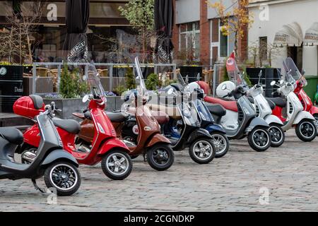 RIGA, Lettland - 4. Mai 2019: Reihe der klassischen Vespa Roller auf dem zentralen Platz der Stadt geparkt Stockfoto