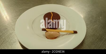 Schokoladen-Mousse-Kuchen mit Haselnussgelato auf einem Servierteller Stockfoto