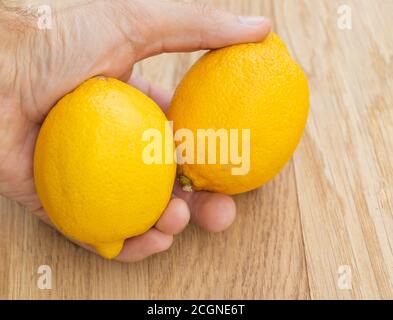 Zwei frische Zitronen in der Hand eines Mannes. Die Vorteile von Zitrone Stockfoto