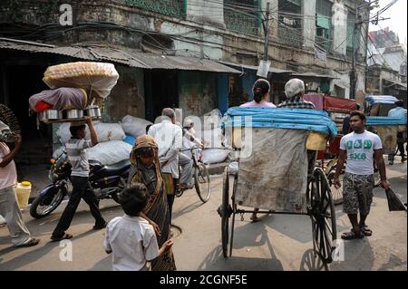 30.11.2011, Kolkata (Kalkutta), Westbengalen, Indien, Asien - EINE Straßenszene zeigt das Treiben mit Fußgängern und einer handgezogenen Rikscha. Stockfoto