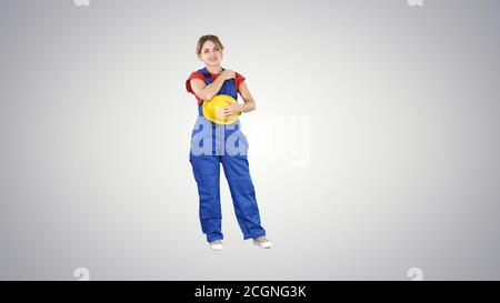 Die junge Frau trägt rotes T-Shirt mit gelbem Schutzhelm ,eng Stockfoto
