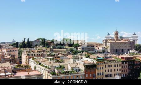 Stadtbild von Rom, Italien an einem sonnigen Tag. Alte Gebäude und Ruinen. Dach mit grünen Pflanzen. Blauer Himmel und weiße Wolken. Stockfoto