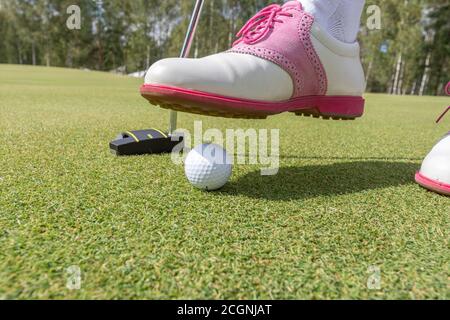 Golfspielerinnen, die sich während des Golfplatzes auf einen Putt auf dem Grün vorbereiten. Stockfoto