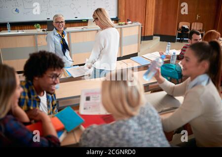 Studenten im Amphitheater in einem entspannten Gespräch über einen Vortrag Stockfoto