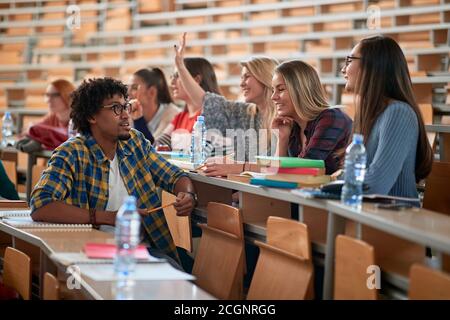 Studenten in einem entspannten Gespräch in einem Amphitheater in einem Pause eines Vortrags Stockfoto