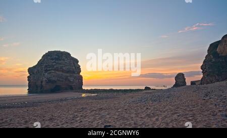 Das Marsden Rock Meer stapelt sich in Marsden Bay in der Nähe von Sunderland in Tyne und tragen während eines Sonnenaufgangs in der Morgendämmerung gefangen. Stockfoto