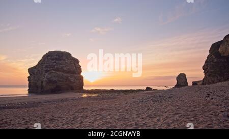 Das Marsden Rock Meer stapelt sich in Marsden Bay in der Nähe von Sunderland in Tyne und tragen während eines Sonnenaufgangs in der Morgendämmerung gefangen. Stockfoto