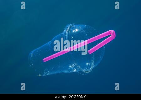 Ein Plastikcocktassen mit Strohhalm schwimmt langsam unter Wasser in blauem Wasser, Budva, Montenegro Stockfoto