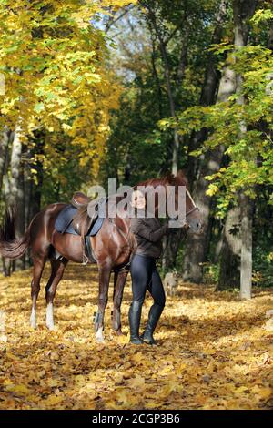 Outdoor-Porträt der jungen schönen Frau mit Pferd gegen die Herbsthintergrund Stockfoto