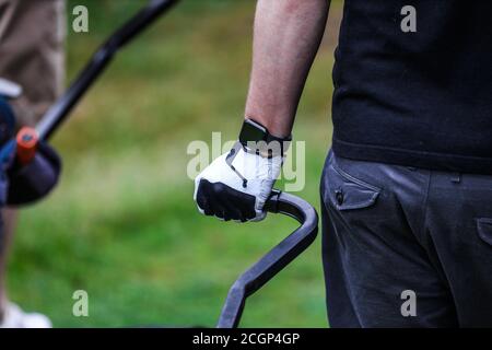 Ein weiterer Tag auf dem Golfplatz. Die Hand des Golfers ist auf dem Griff der Tasche Stockfoto