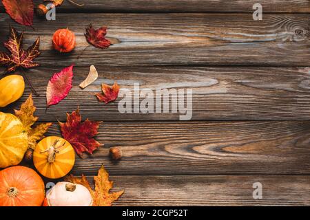 Herbst oder Danksagung Zusammensetzung aus Herbstblättern, Blumen, Kürbis, Nüsse auf rustikalem Holzhintergrund. Flach liegend, Draufsicht mit Kopierplatz Stockfoto