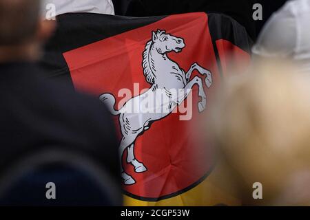 Braunschweig, Deutschland. September 2020. Auf der Landespartei der Niedersächsischen Partei Alternative für Deutschland (AfD) wird über einem Stuhl eine Flagge mit dem niedersächsischen Staatswappen aufgehängt. Auf der Landespartei-Konferenz soll ein neuer Vorstand gewählt werden. Quelle: Swen Pförtner/dpa/Alamy Live News Stockfoto