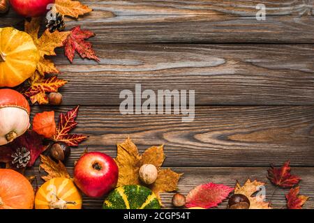 Thanksgiving, Halloween oder Herbst Hintergrund. Herbstzusammensetzung mit Kürbissen, Äpfeln, Blättern, trockenen Blumen und Nüssen auf rustikalem Holztisch. Flach liegend, t Stockfoto