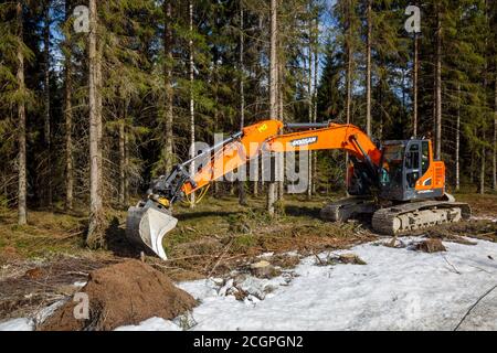 Orange Doosan DX235LCR Bagger im Wald, Finnland Stockfoto