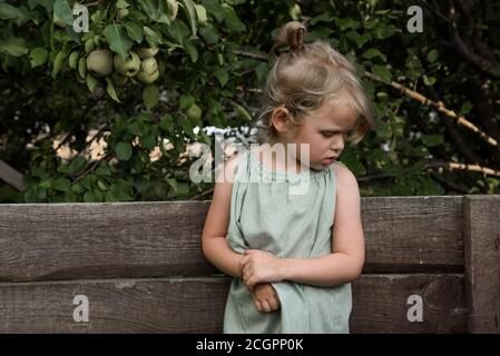 Kleines Mädchen schaut nachdenklich nach unten Stockfoto