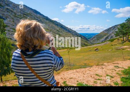 Reife Frau, die Fotos von der Landschaft. Heiligtum von El Brezo, Villafria de la Peña, Provinz Palencia, Castilla Leon, Spanien. Stockfoto