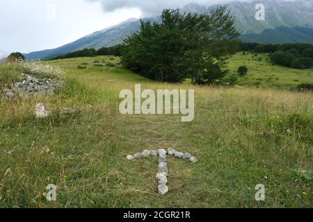 Pfeil in Steinen zeigt die Richtung des Weges in Der san leonardo Pass auf dem Berggebiet des maiella in den abruzzen Stockfoto