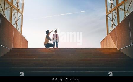 Vater und Kind klettern nach oben. Familie sieht fliegen im Flugzeug. Stockfoto