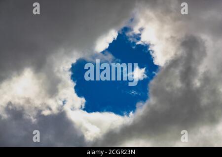 Blaues Loch gucken durch die Wolken Stockfoto