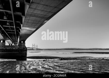 Prince of Wales Bridge, Severn Beach, vom Strand aus gesehen, mit dem Gezeitenwasser, das die Wellen im Schlamm zeigt Stockfoto