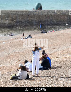 Brighton UK 12. September 2020 - Brighton Strand Besucher an einem sonnigen, aber luftigen Tag als heißes Wetter wird prognostiziert, dass in ganz Großbritannien in den nächsten Tagen zu verbreiten .. : Credit Simon Dack / Alamy Live News Stockfoto