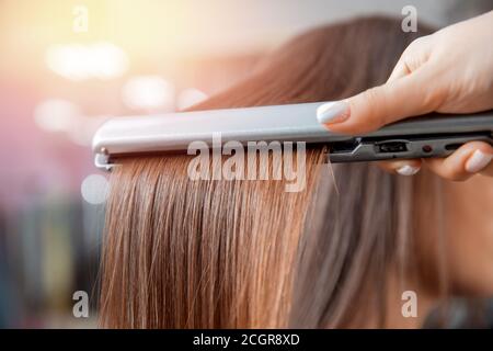 Keratin Erholung und Behandlung mit professionellen Eisen-Tool. Laminiert lange dunkel glänzend Haar Nahaufnahme Stockfoto