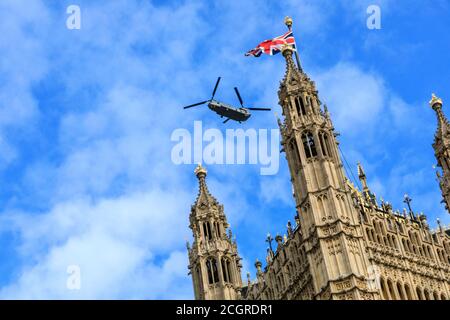 Ein Boeing CH-47 Chinook Hubschrauber fliegt die Houses of Parliament, Westminster, London, England Stockfoto