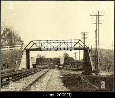 . Die Straßenbahn Zeitschrift . -vate Eigentum, und bei der Firma Ithan Steinbruch. Die Brücken bestehen aus stark verstärktem Beton, der gemäß den standardmäßigen Belastungsspezifikationen der Pennsylvania Railroad ausgelegt ist. Die Abutments sind auf vier Gleise zurückgestellt, so dass, wenn die Straße bereit ist für expre?s servicedie Kosten und Zeit für Änderungen erforderlich werden sehr beleuchtet^^le. Alle Bögen sind aus Beton, verstärkt mit schadstoffrunden Stäben aus Stahl mit hoher Kohlenstoffreißfestigkeit, die eine Belastung von 15,000 lbs. Pro Quadratzoll aushalten können. Die einfache Wiedererzwingung wurde vor speziellen Formen gewählt Stockfoto