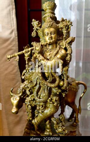 Eine feine detaillierte Messing handgemachte Statue von Lord Krishna mit Flöte und Kuh. Stockfoto