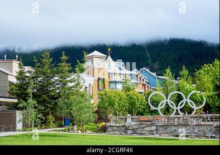 Panoramablick auf Wistler Skigebiet Dorf und die Berge als Hintergrund im Sommer, mit grünem Park und die olympischen Ringe vor Stockfoto