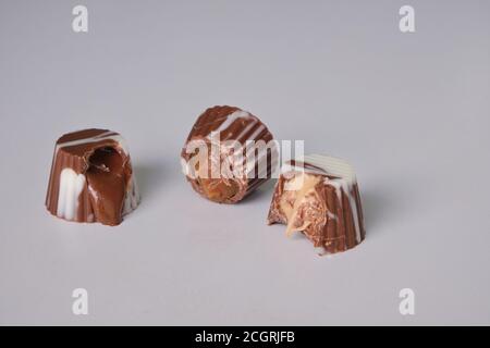 Dunkle Schokolade, Milchschokolade und weiße Schokoladenbonbons. Gefüllt mit Erdnussbutter, Dulce de leche, Kondensmilch und Haselnusscreme Stockfoto