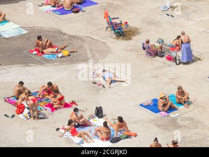 Las Palmas, Gran Canaria, Kanarische Inseln, Spanien. September 2020. Einheimische, einige mit Gesichtsmasken, sonnen sich neben natürlichen Felsenpools an der zerklüfteten Nordküste Gran Canarias, wenn Covid-Fälle auf der Insel aufsteigen, Aufgrund der kurenten Spitze bei Coronavirus-Fällen in Spanien und den kanarischen Inseln haben Großbritannien und Deutschland Spanien und die Kanarischen Inseln auf ihre Quarantäneliste gesetzt. Der Großteil der Neuinfektionen auf Gran Canaria liegt in der Hauptstadt Las Palmas. Kredit: Alan Dawson/Alamy Live Nachrichten Stockfoto