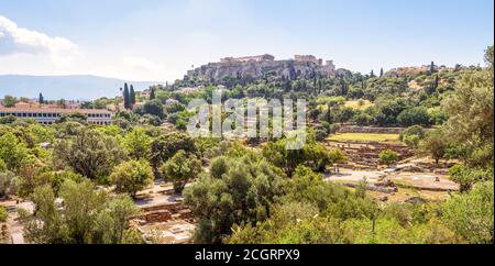 Antike Agora in Athen, Griechenland. Panoramablick auf griechische Ruinen und Akropolis in der Ferne. Urbane Landschaft des alten Athen im Sommer. Landschaft von Touristen Stockfoto