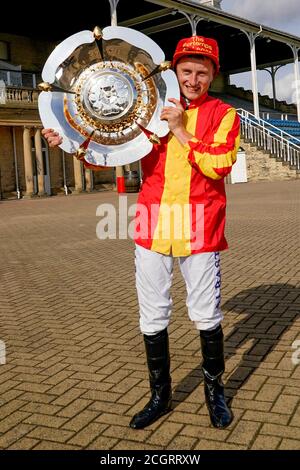 Jockey Tom Marquand feiert mit der Trophäe und Kappe nach dem Reiten Galileo Chrome, um die Pertemps St Leger Stakes während des vierten Tages des William Hill St Leger Festival auf Doncaster Racecourse zu gewinnen. Stockfoto