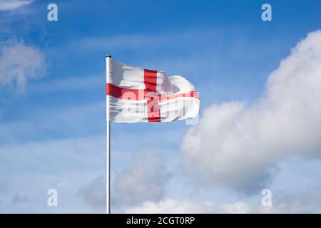 Die Flagge Englands, ein rotes Kreuz, das auf einem weißen Feld aus dem Georgskreuz zentriert ist, flattert in der Brise gegen einen blauen Sommerhimmel Stockfoto